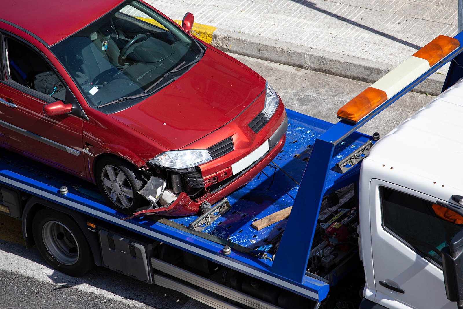 Crashed car loaded on a tow truck. Damage vehicle after crash ac Professional accident recovery towing for damaged vehicles in EdmontonProfessional accident recovery towing for damaged vehicles in Edmonton, Towing and roadside assistance in Edmonton for accident vehicle recovery
