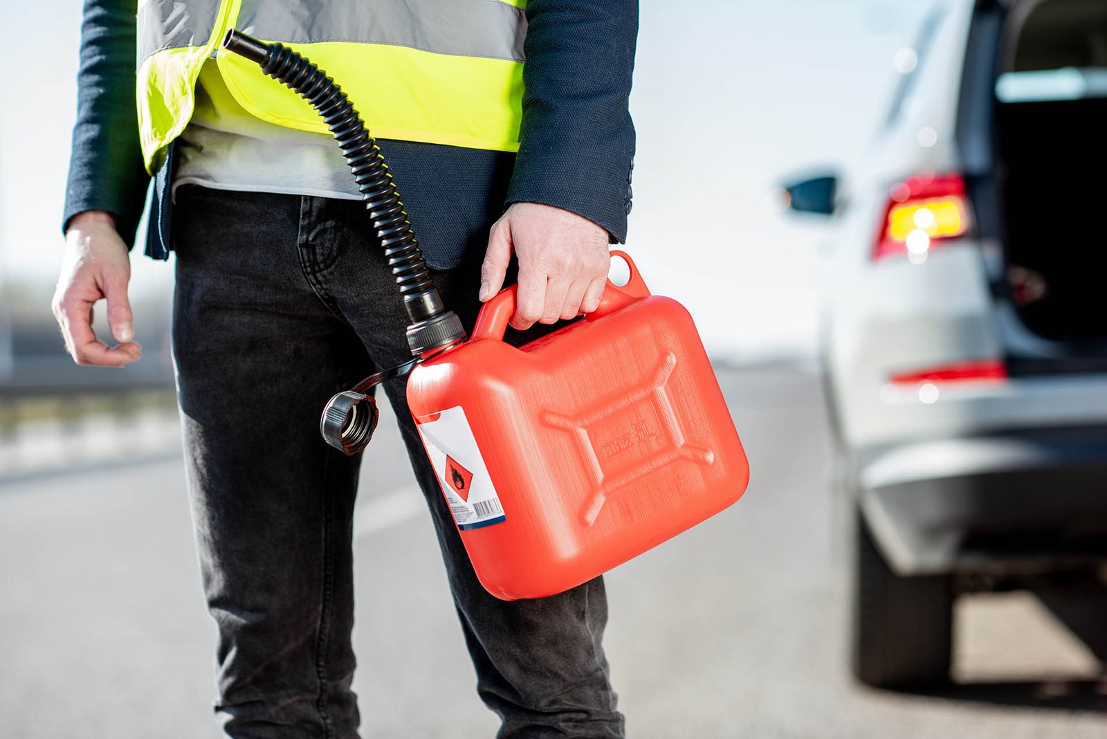 Man with refuel canister on the roadside Emergency fuel delivery roadside assistance for drivers in Edmonton